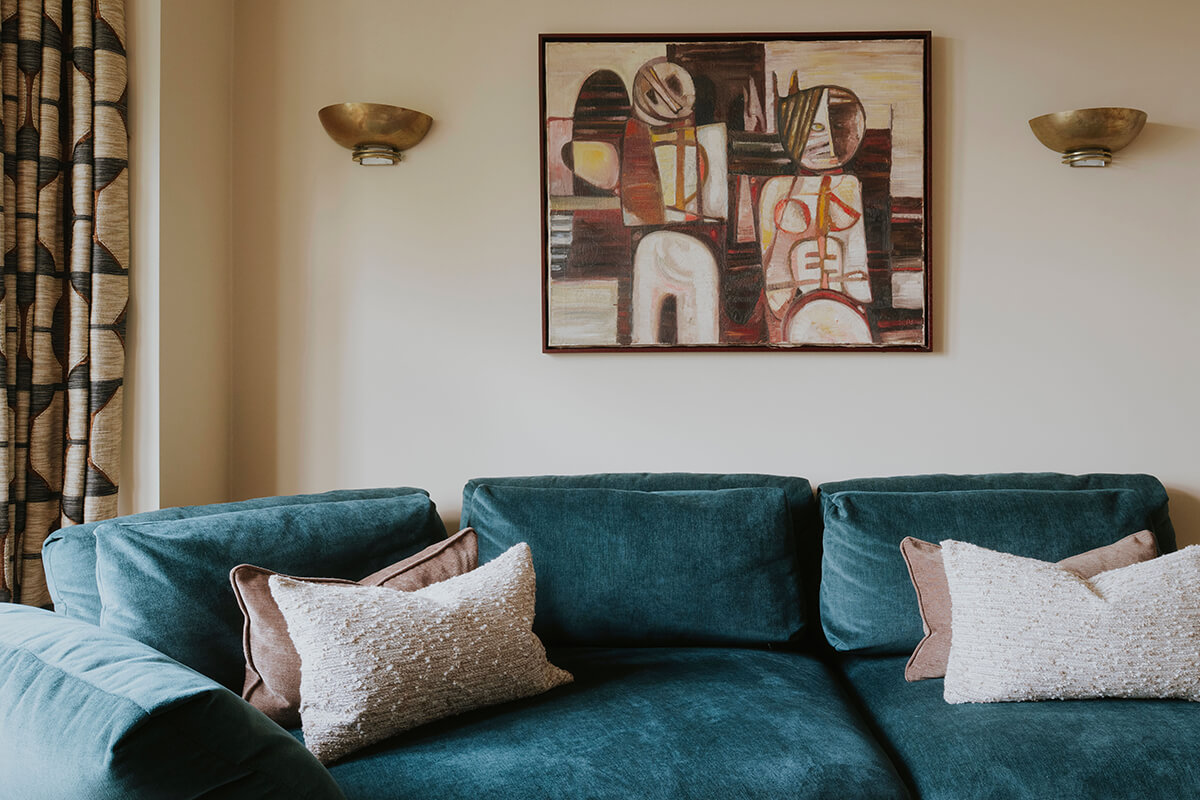 The Haven Sofa with keystone chaise in deep teal, styled in a teal living room with brass joinery and gold light fixtures.