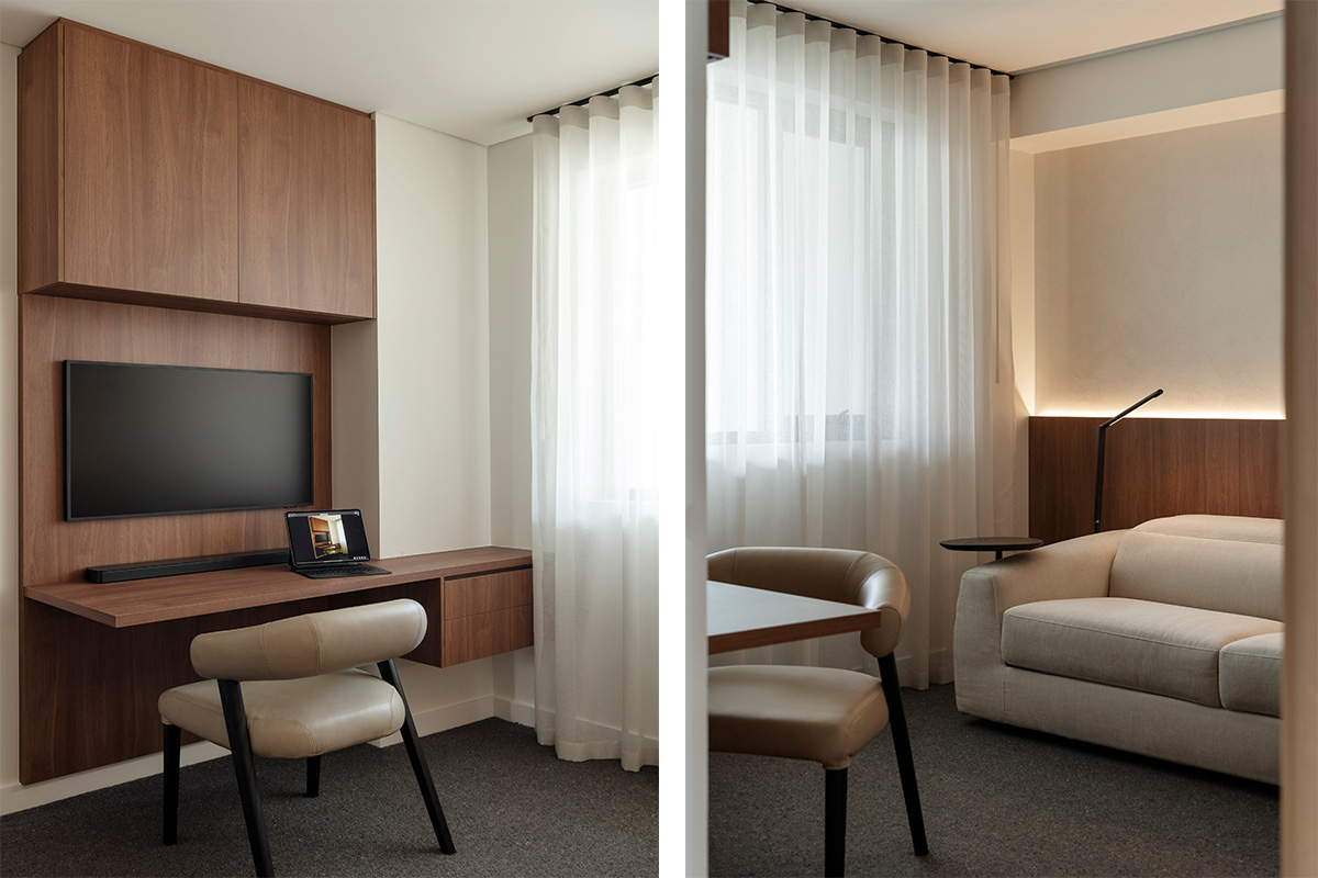Modern workspace with a wooden desk and TV and a neutral sofa with soft lighting, and sheer curtains.
