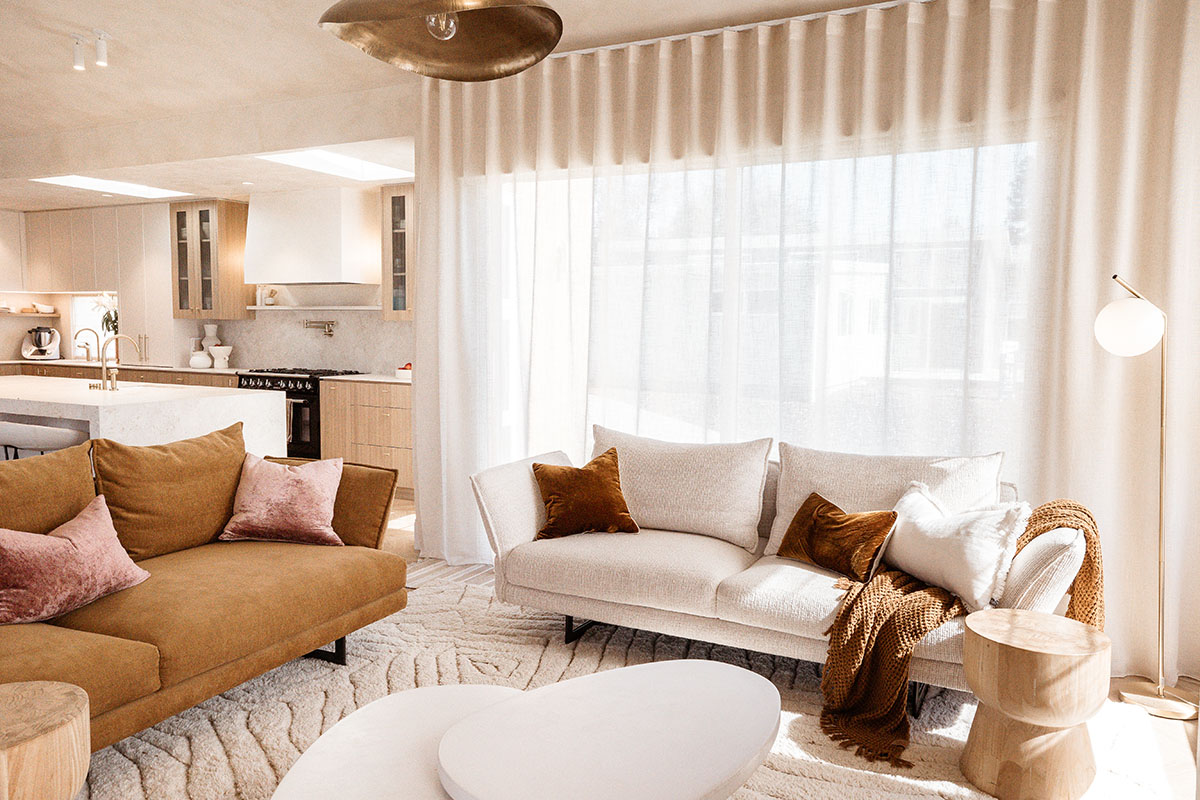 Two King Living sofas in complementary earthy tones ground a modern, light-filled living space.